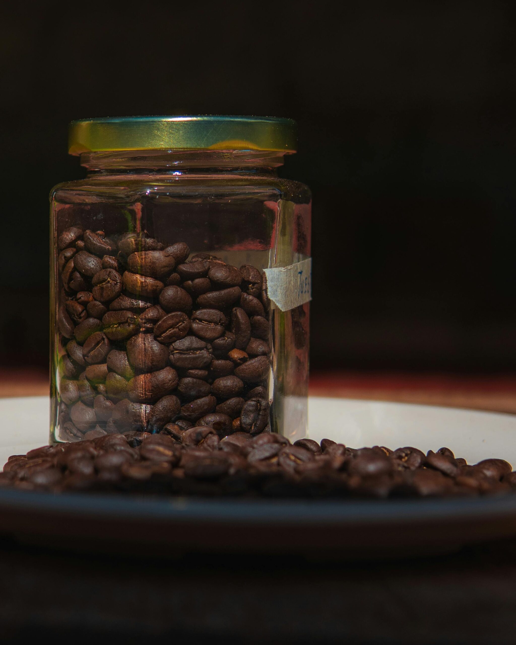 Close-up of organic coffee beans in a glass jar on a dark background in Puebla, Mexico.